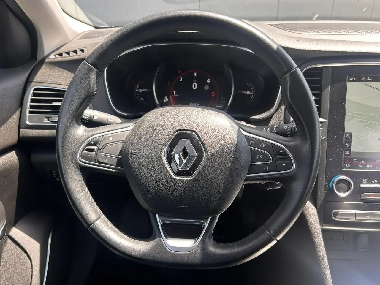 Vue rapprochée du volant cuir d’une Renault Mégane IV Diesel 2020 avec tableau de bord numérique et écran tactile 8,7 pouces.