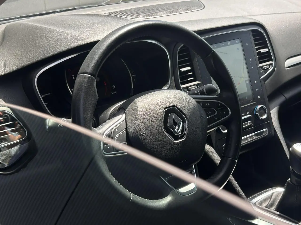 Vue intérieure centrée sur le volant cuir Nappa et l’écran tactile 8,7 pouces de la Renault Mégane IV Gris Titanium.