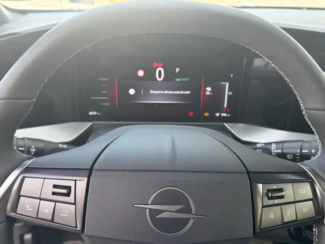 Vue rapprochée du volant noir de l’Opel Mokka électrique 2025 avec tableau de bord numérique allumé.
