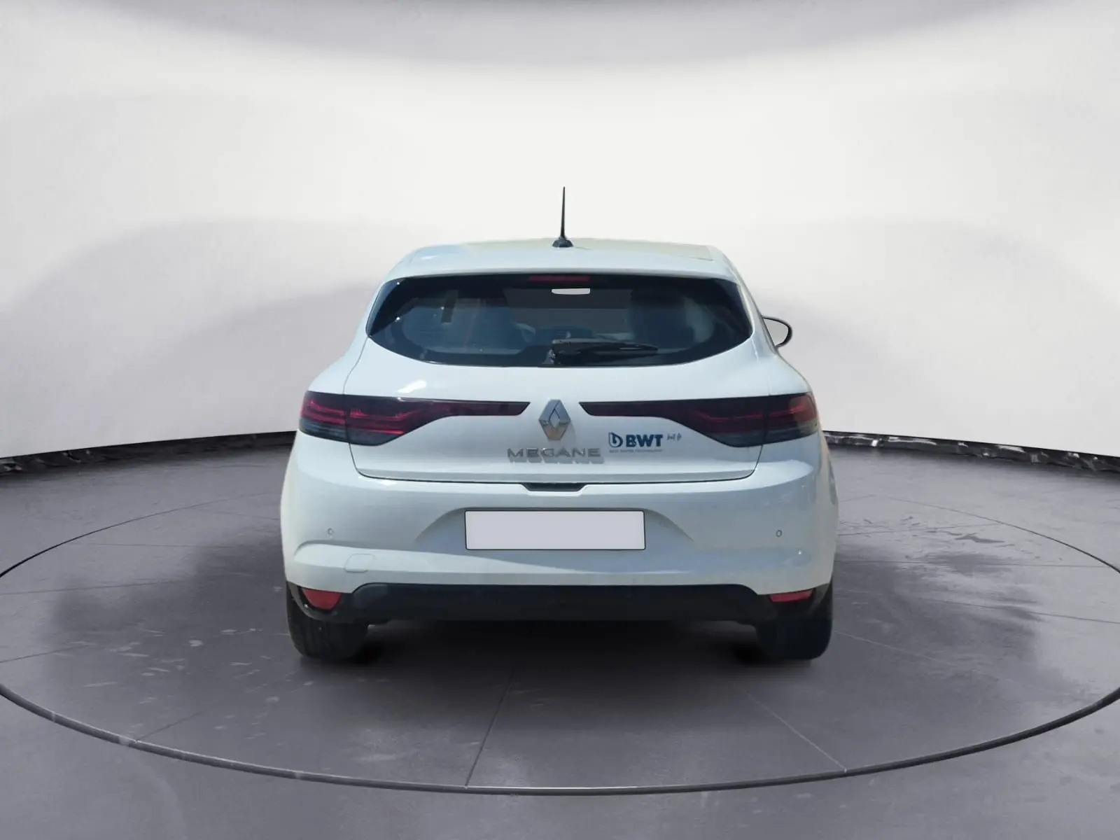 Coffre ouvert vu de l’arrière d’une Renault Mégane blanche 2022, avec intérieur de coffre noir et hayon relevé.