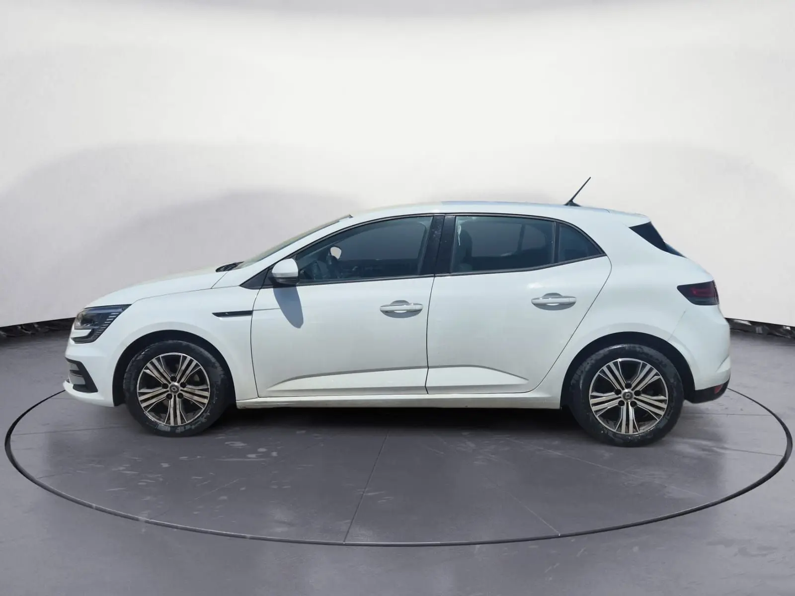 Renault Mégane blanche vue 3/4 arrière droit sur un parking, avec feux arrière LED et jantes alliage.
