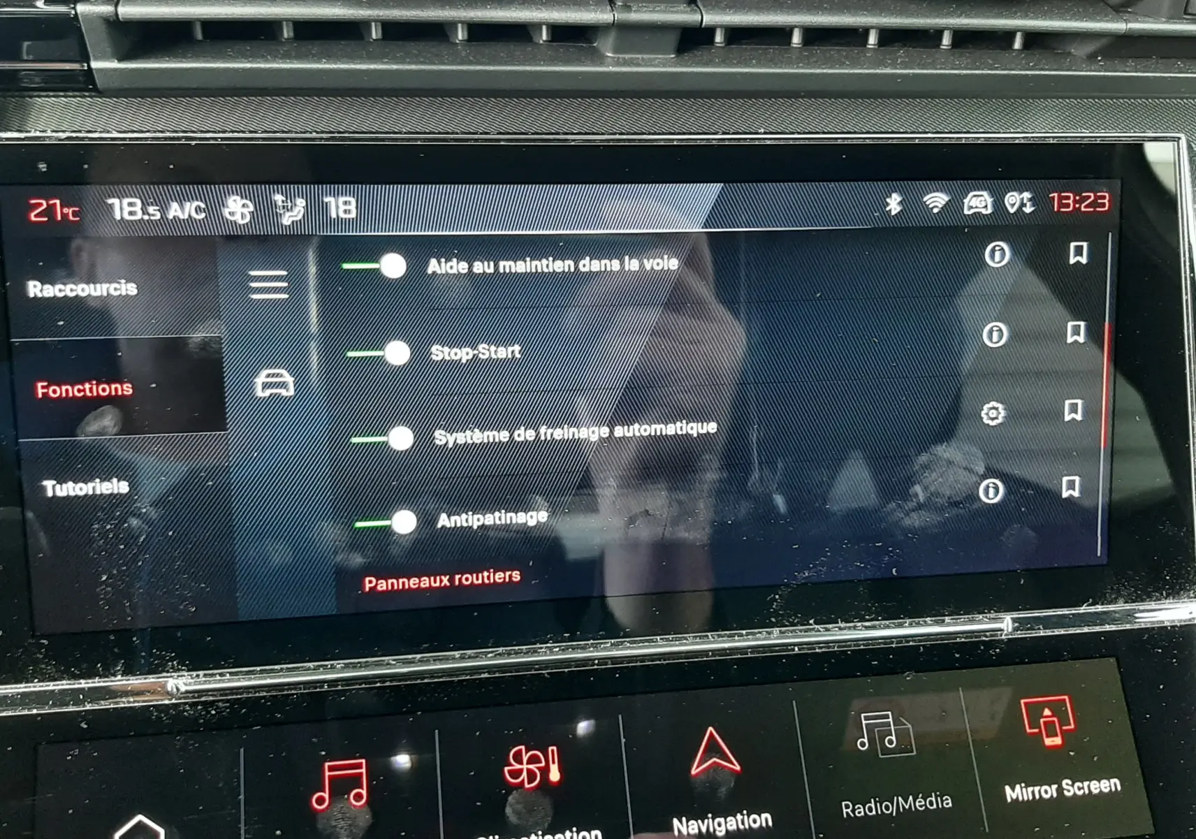 Écran tactile central du tableau de bord de la Peugeot 308 SW blanc Okenite, affichant les options d’aide à la conduite.