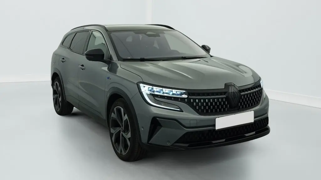 Renault Espace E-Tech gris schiste en 3/4 avant droit, avec calandre à damiers et feux LED allumés.