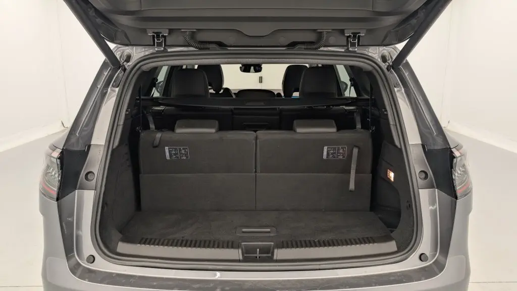Coffre ouvert vu de l'arrière d'un Renault Espace 2025 gris schiste, montrant la banquette arrière et l'espace de chargement.