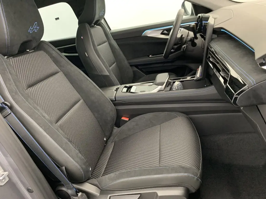 Intérieur côté conducteur du Renault Espace E-Tech gris, sièges alcantara noirs avec surpiqûres bleues et tableau de bord moderne.
