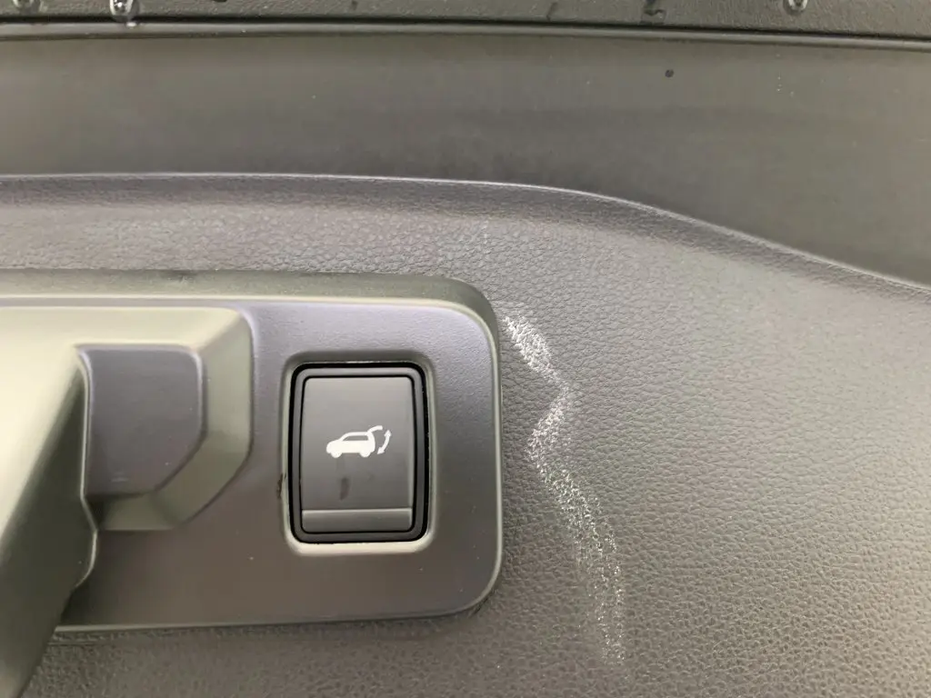 Bouton d'ouverture du hayon motorisé sur panneau intérieur noir du Renault Espace E-Tech hybride 2025.