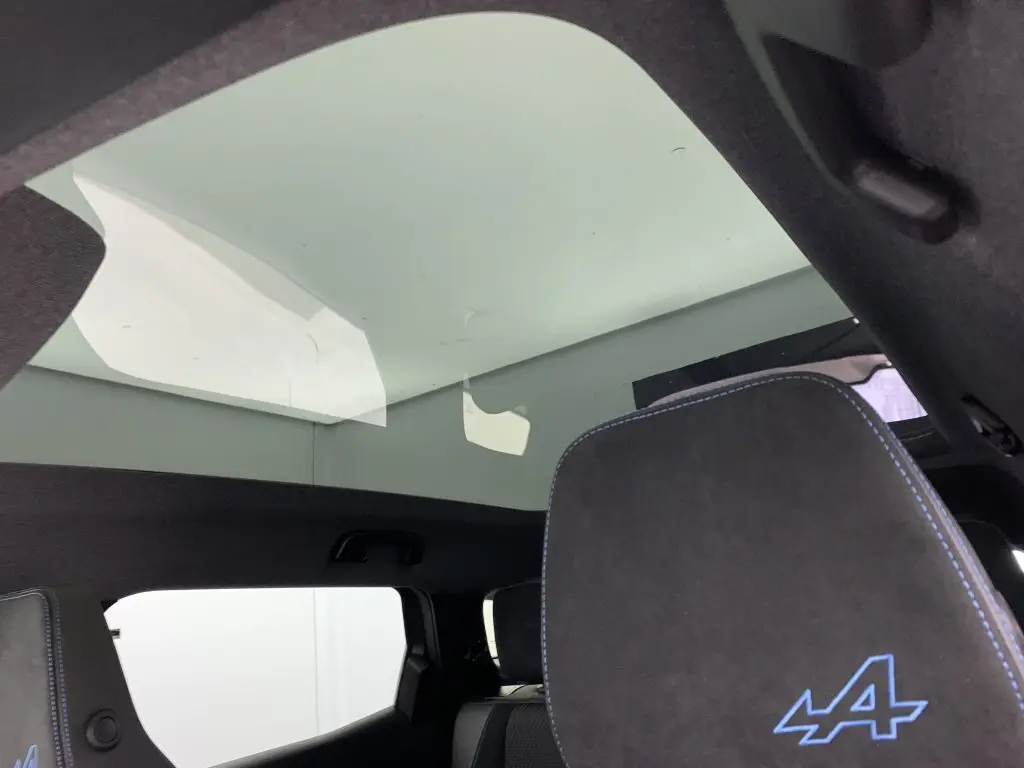 Toit panoramique en verre et appuie-tête avant gris anthracite avec logo Alpine bleu dans un Renault Espace 2025.