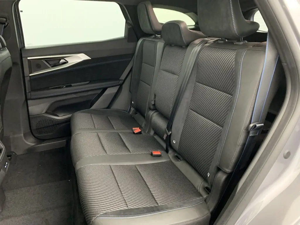 Banquette arrière en sellerie mixte tissu carbone et alcantara noire avec surpiqûres bleues dans Renault Espace 2025 côté droit.