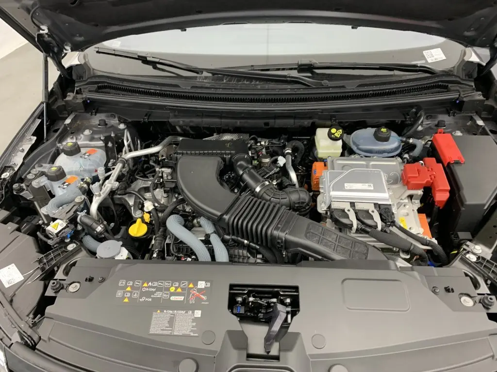Moteur hybride visible sous le capot ouvert d'un Renault Espace 2025 gris schiste, vue de face détaillée.