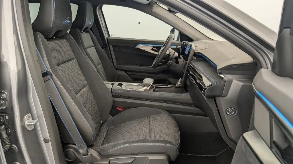 Vue intérieure côté conducteur du Renault Espace E-Tech gris avec sellerie tissu carbone et surpiqûres bleues esprit Alpine.