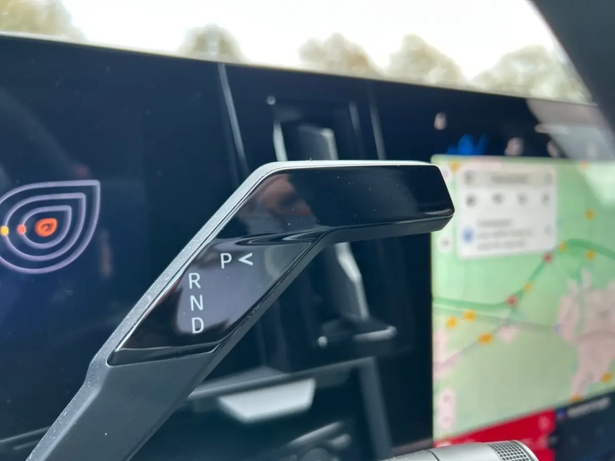 Le levier de vitesses automatique noir de la Renault Rafale hybride, avec écran tactile de navigation en arrière-plan.