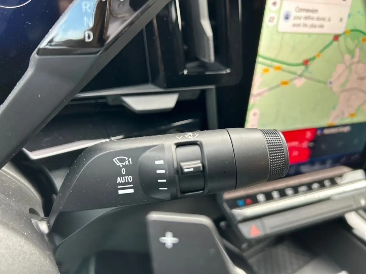 Gros plan sur la commande d'essuie-glace à gauche du volant du Renault Rafale noir, avec écran tactile de navigation visible.