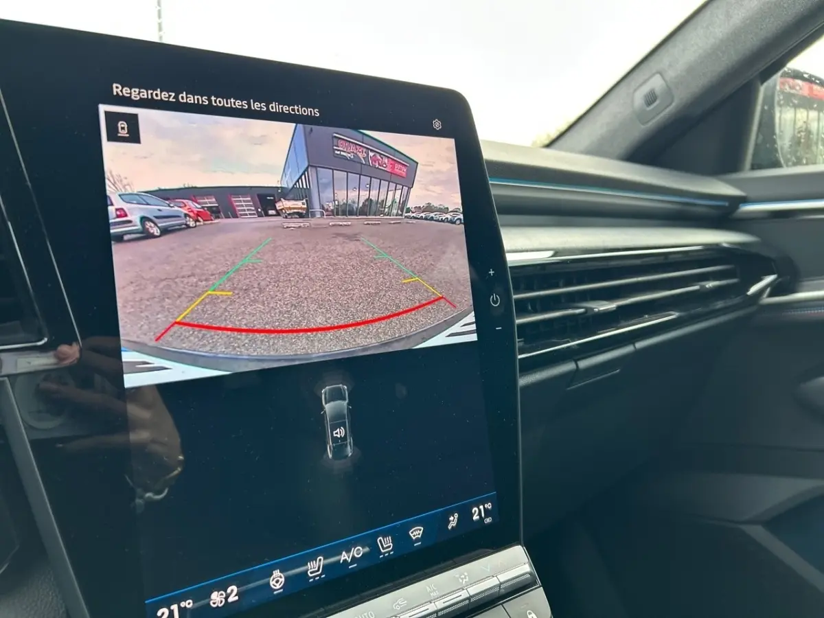 Vue intérieure du tableau de bord de la Renault Rafale noir, avec écran tactile affichant la caméra de recul en marche.