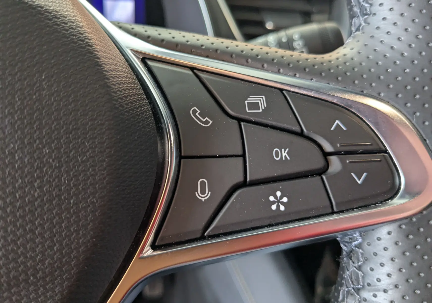 Gros plan sur les commandes multifonctions noires à droite du volant perforé du Renault Symbioz gris Cassiopée 2025.