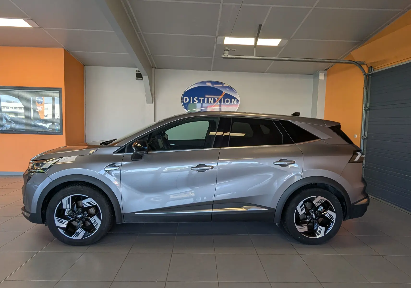 Vue latérale droite du Renault Symbioz E-Tech Full Hybrid gris cassiopée, avec jantes bicolores et lignes modernes.