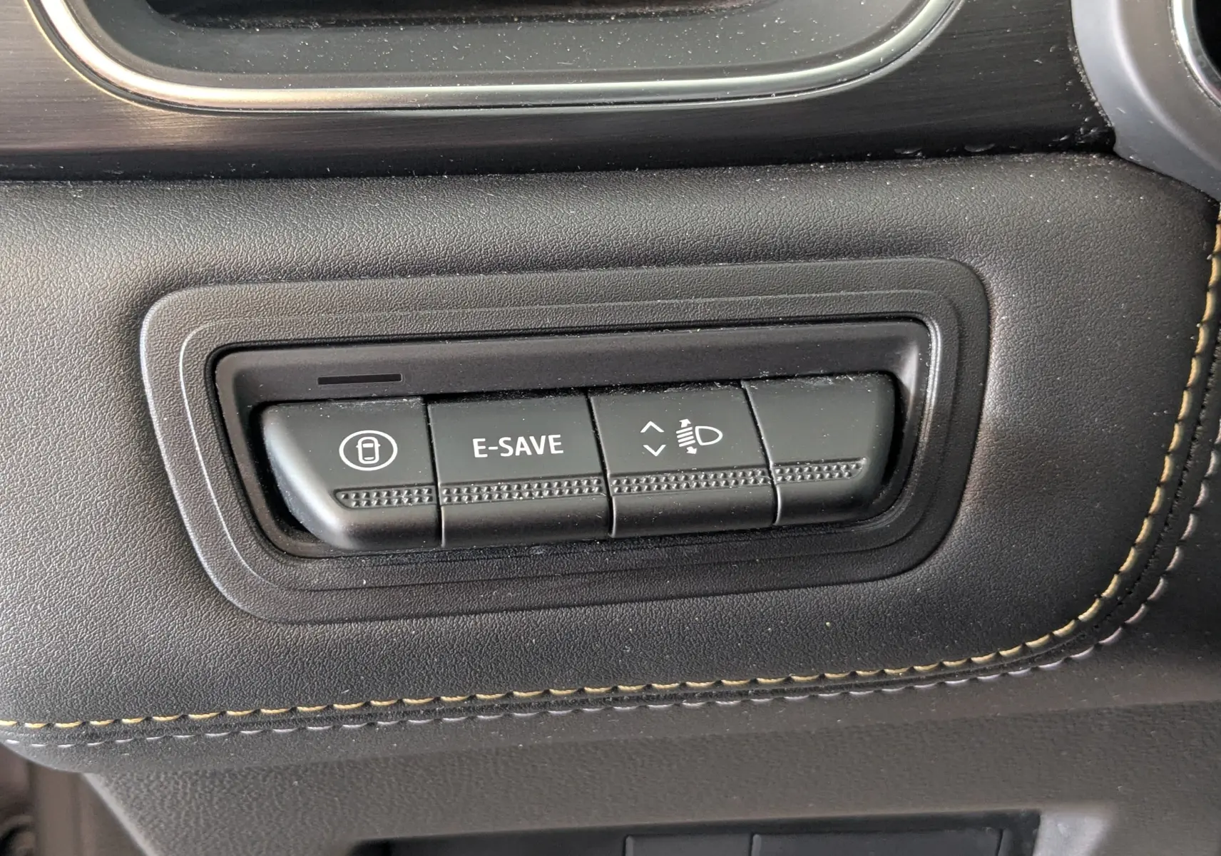 Gros plan sur les boutons de commande noirs avec surpiqûres beiges dans l’habitacle du Renault Symbioz E-Tech Full Hybrid 2025.
