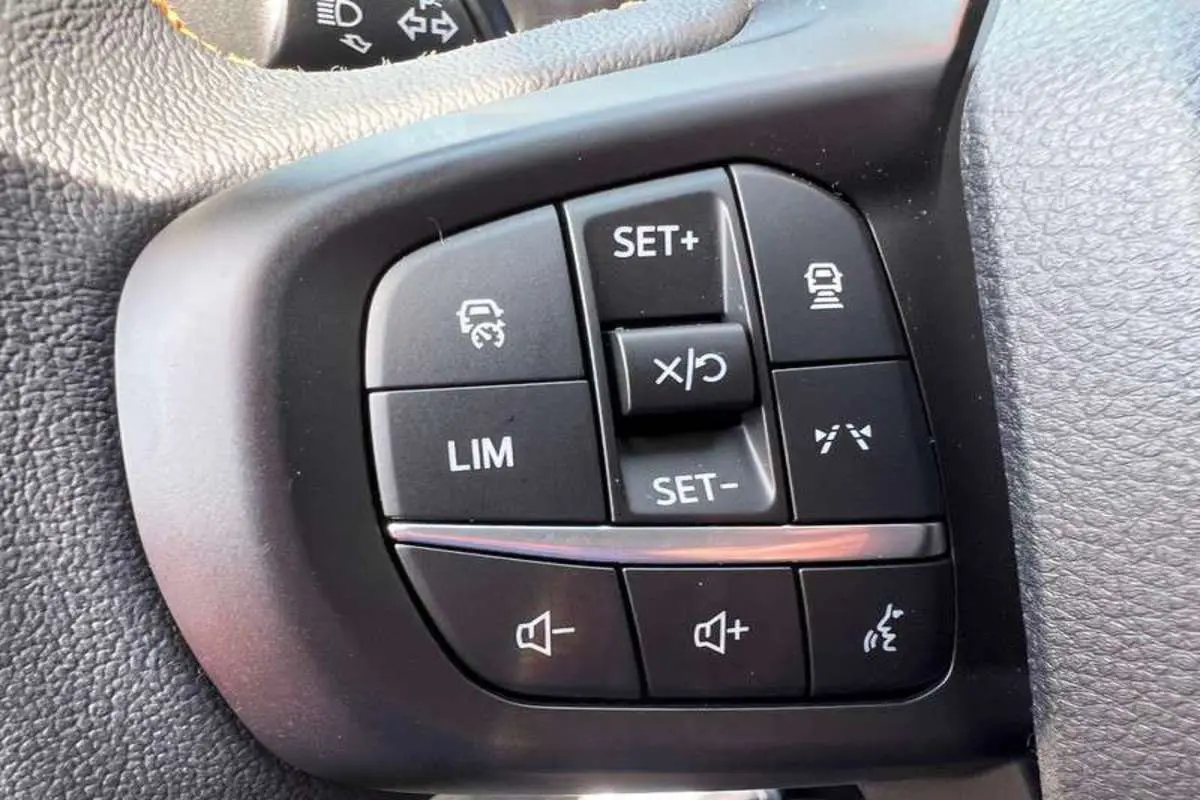 Gros plan sur les commandes multifonctions noires du volant du Ford Ranger Wildtrak Plus 2025.