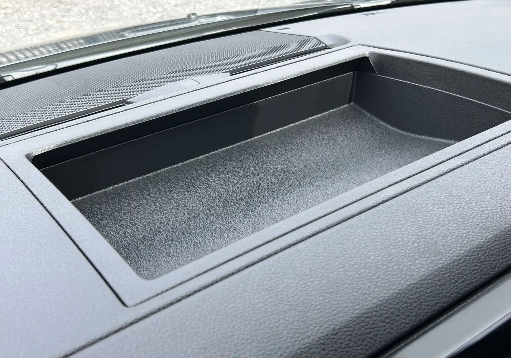 Espace de rangement noir intégré au tableau de bord du Citroën Jumpy Fourgon gris acier, vue rapprochée intérieure.