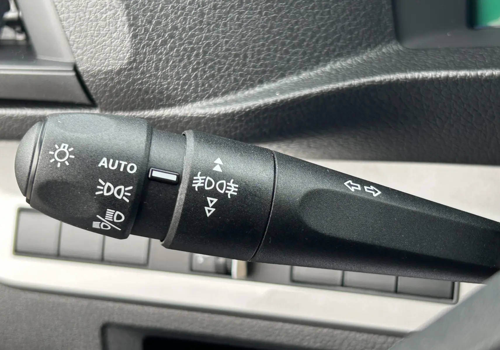 Gros plan sur la commande des phares et clignotants du Citroën Jumpy Fourgon gris acier, intérieur noir texturé.
