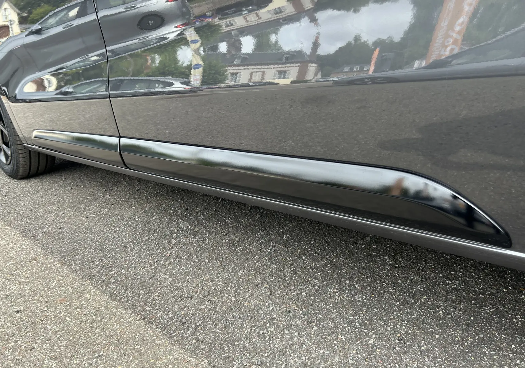 Gros plan sur la partie basse côté gauche du Citroën Jumpy Fourgon gris acier, mettant en valeur la protection latérale noire.