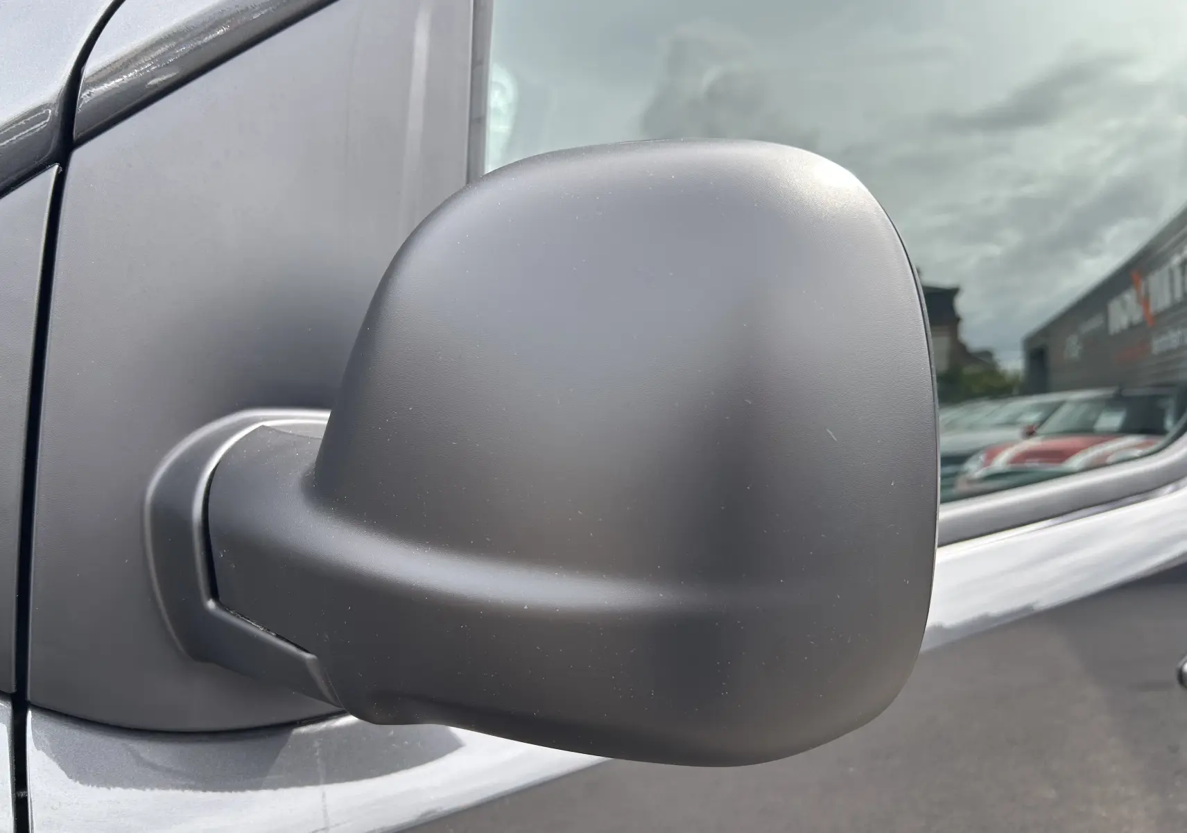 Rétroviseur droit noir mat en gros plan sur un Citroën Jumpy Fourgon gris acier 2025 stationné extérieur.