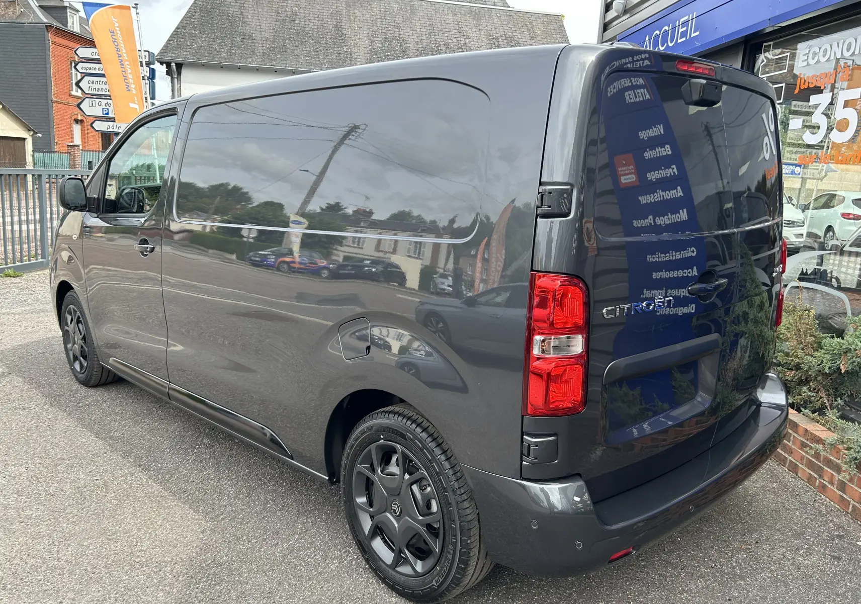 Vue 3/4 arrière droite du Citroën Jumpy Fourgon gris acier, mettant en valeur ses feux arrière et jantes noires.
