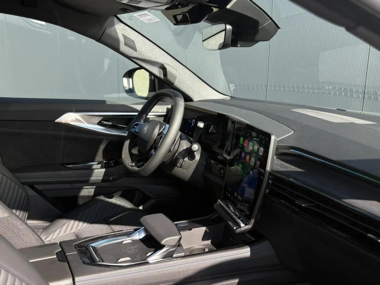 Intérieur du Renault Austral E-Tech gris, vue côté conducteur montrant volant Alcantara et écran tactile vertical.