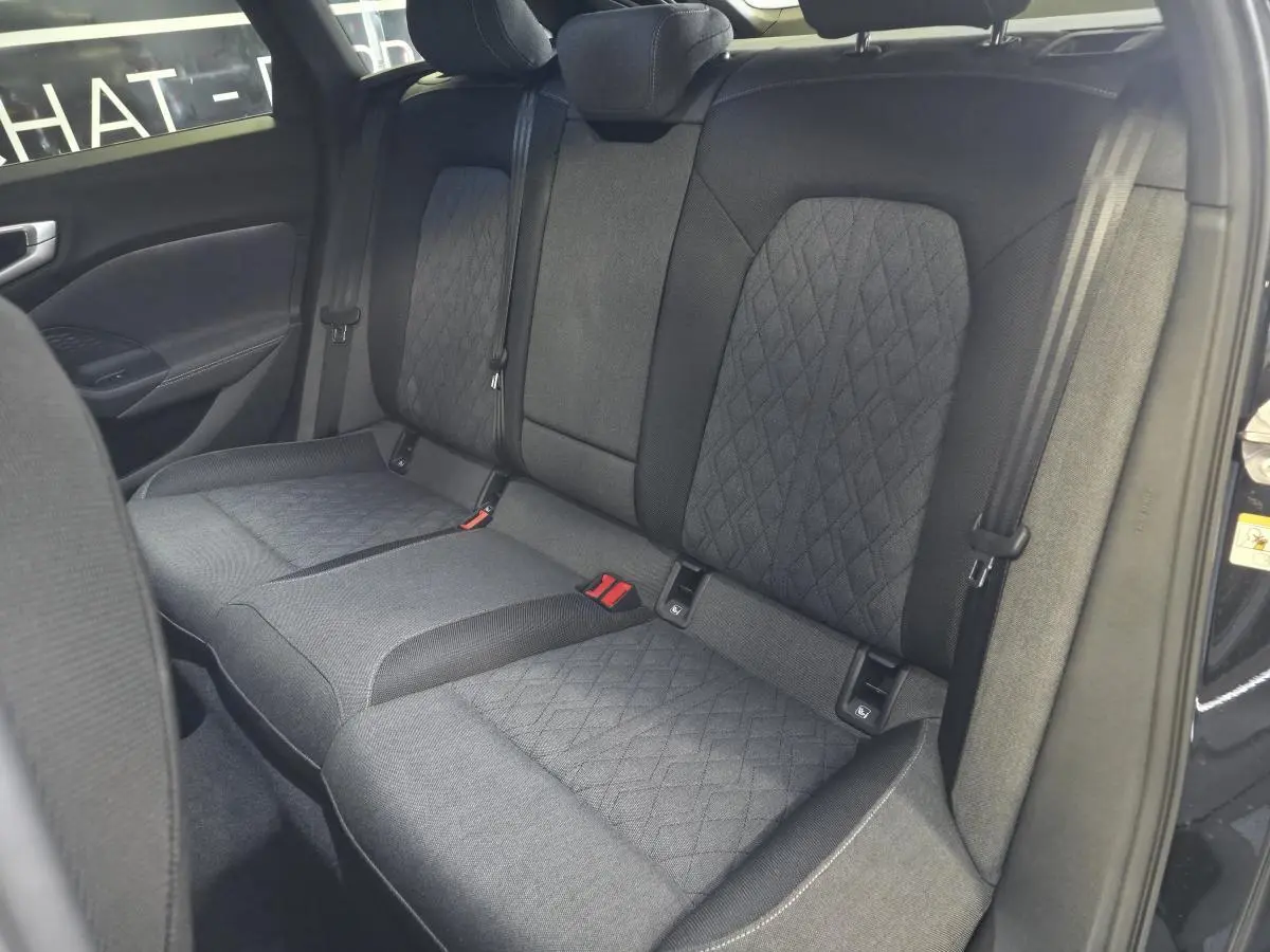 Vue intérieure du siège arrière tissu noir avec surpiqûres beige de l'Audi A5 Avant 2025 côté droit ouvert.