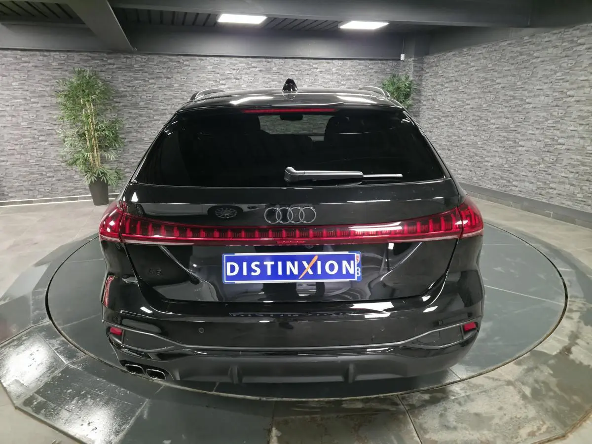 Vue arrière d'un break Audi A5 Avant noir avec feux arrière LED continus et double sortie d'échappement chromée.