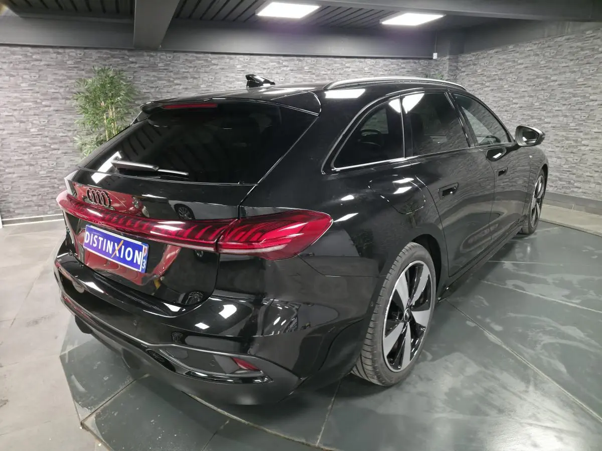Audi A5 Avant noir vue 3/4 arrière droit, avec feux arrière LED et jantes 19 pouces bicolores.