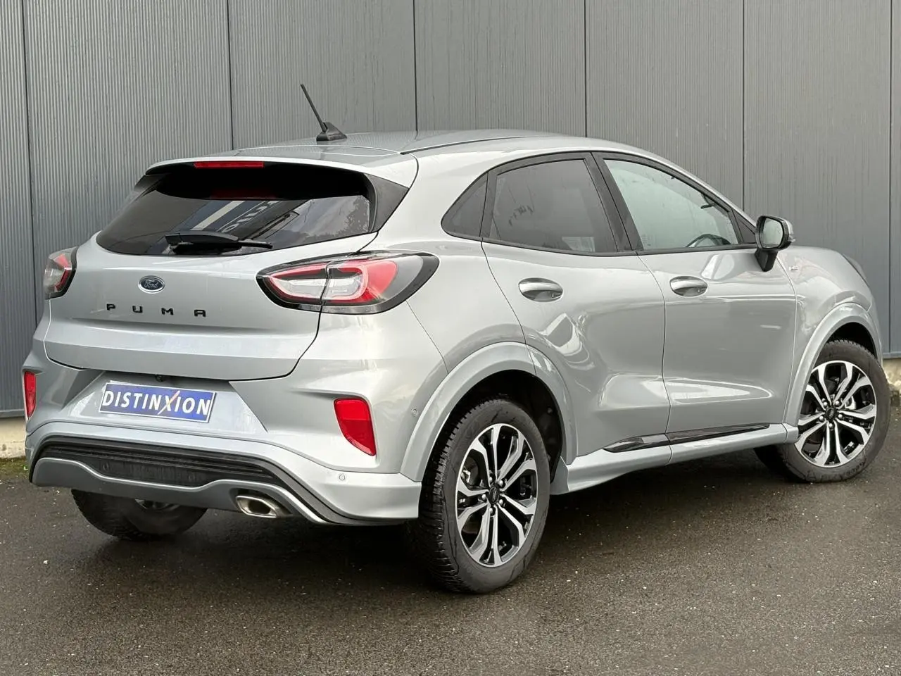 Vue 3/4 arrière droite du Ford Puma gris Solar avec jantes alliage 17 pouces et hayon électrique visible.