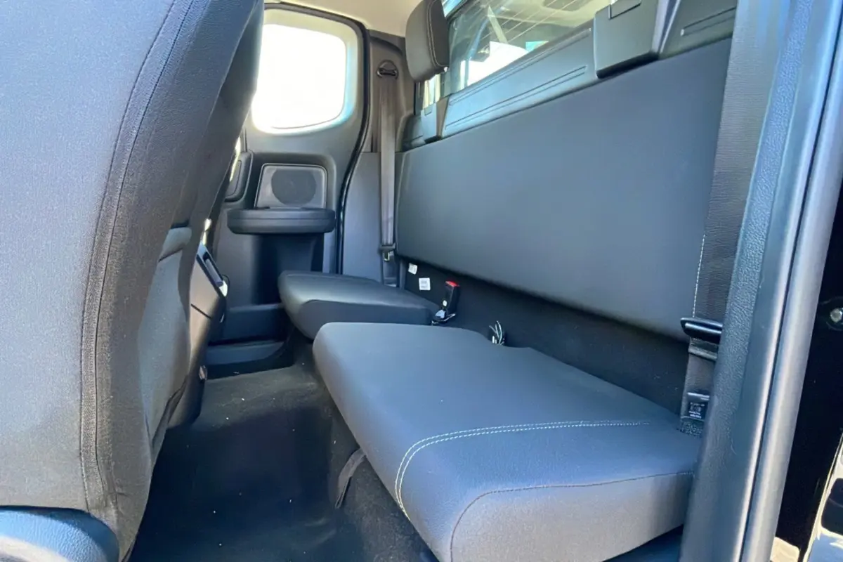Vue intérieure arrière côté droit du Ford Ranger noir shadow avec banquette et fenêtre de cabine arrière.