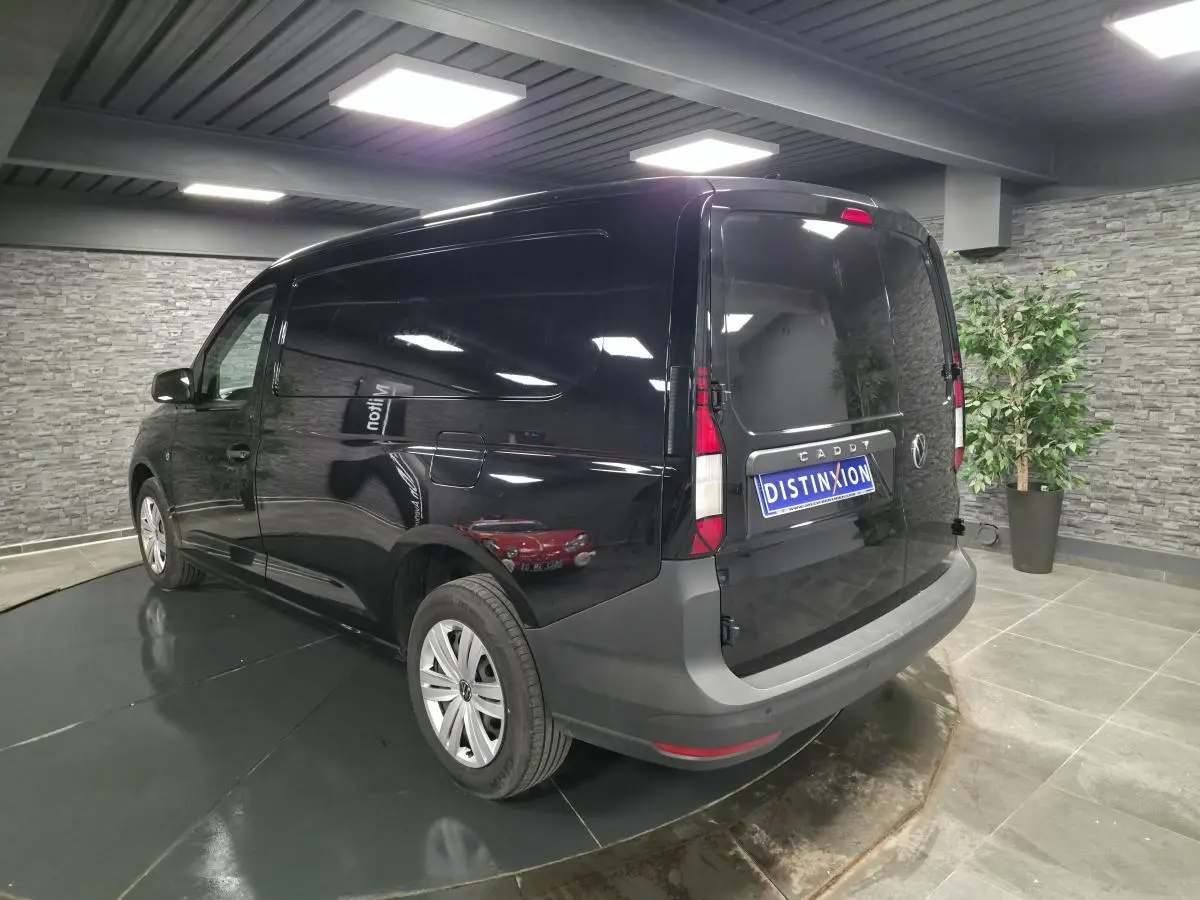 Vue 3/4 arrière droite d'un Volkswagen Caddy Cargo noir avec portes arrière battantes et jantes acier.