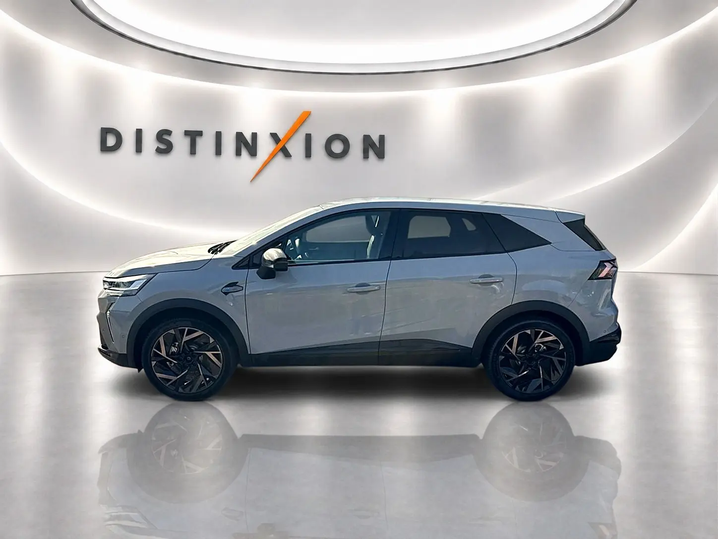 Renault Symbioz gris rafale en profil droit dans un showroom lumineux avec jantes noires distinctives.