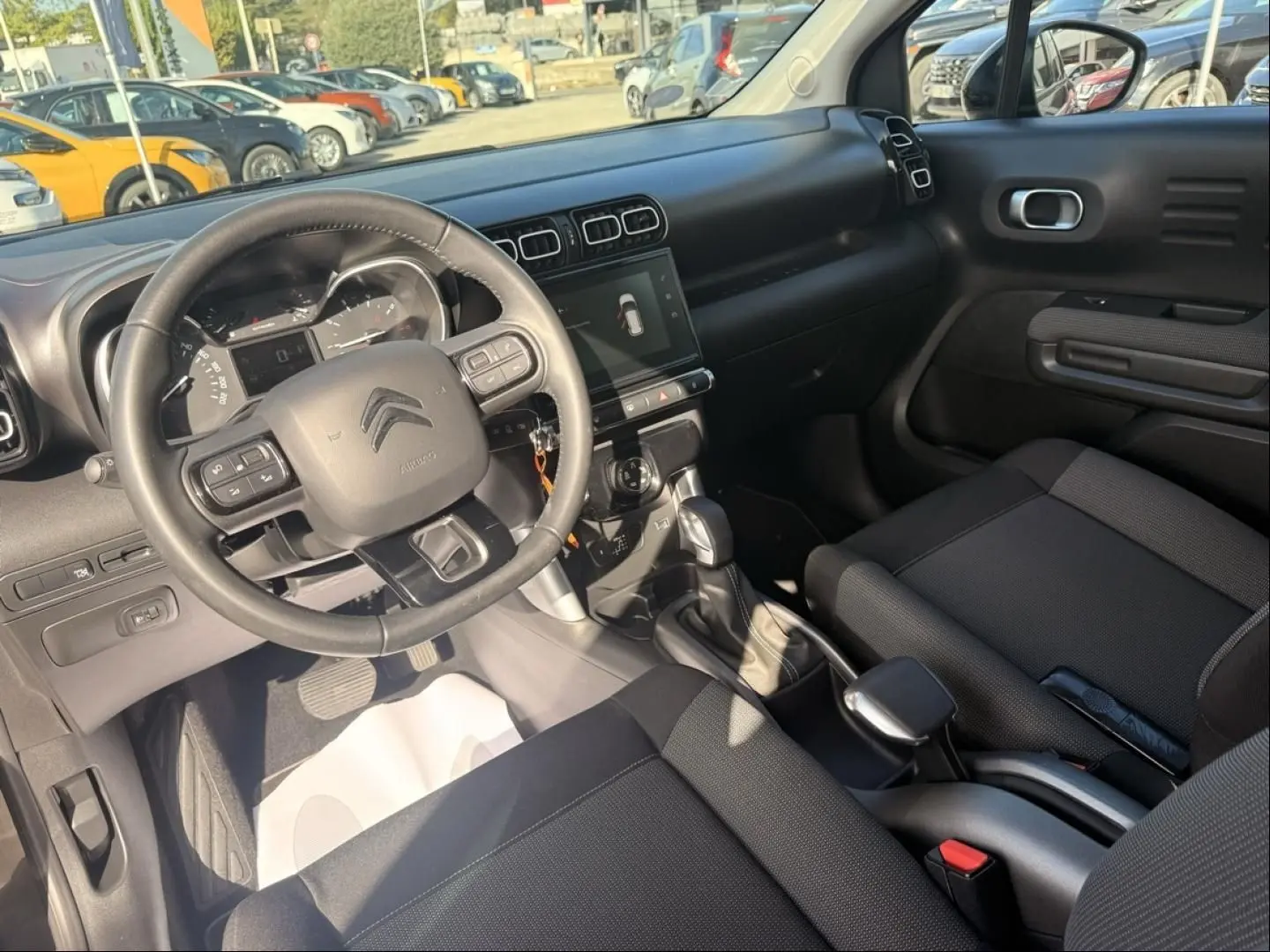 Vue intérieure côté conducteur du Citroën C3 Aircross 2021, tableau de bord noir et volant multifonctions.