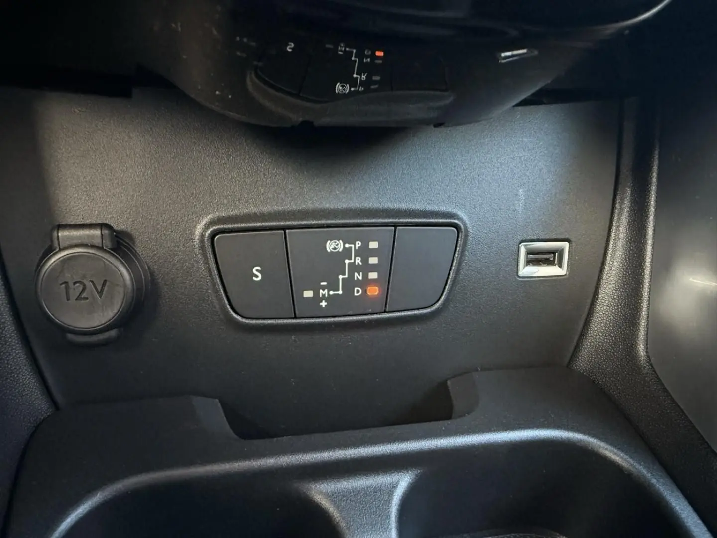 Gros plan sur la commande de boîte automatique et prise 12V du Citroën C3 Aircross gris métal, version PureTech 130 CV Shine EAT6.