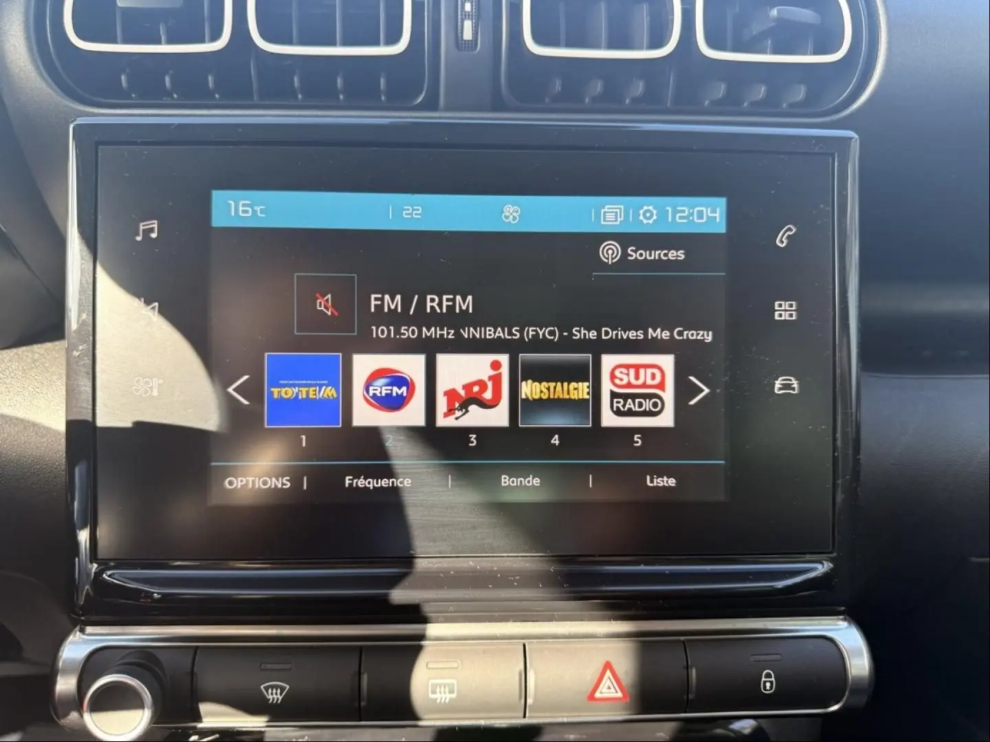 Écran tactile central du Citroën C3 Aircross gris métal 2021, affichant les stations radio FM avec commandes climatisation en dessous.