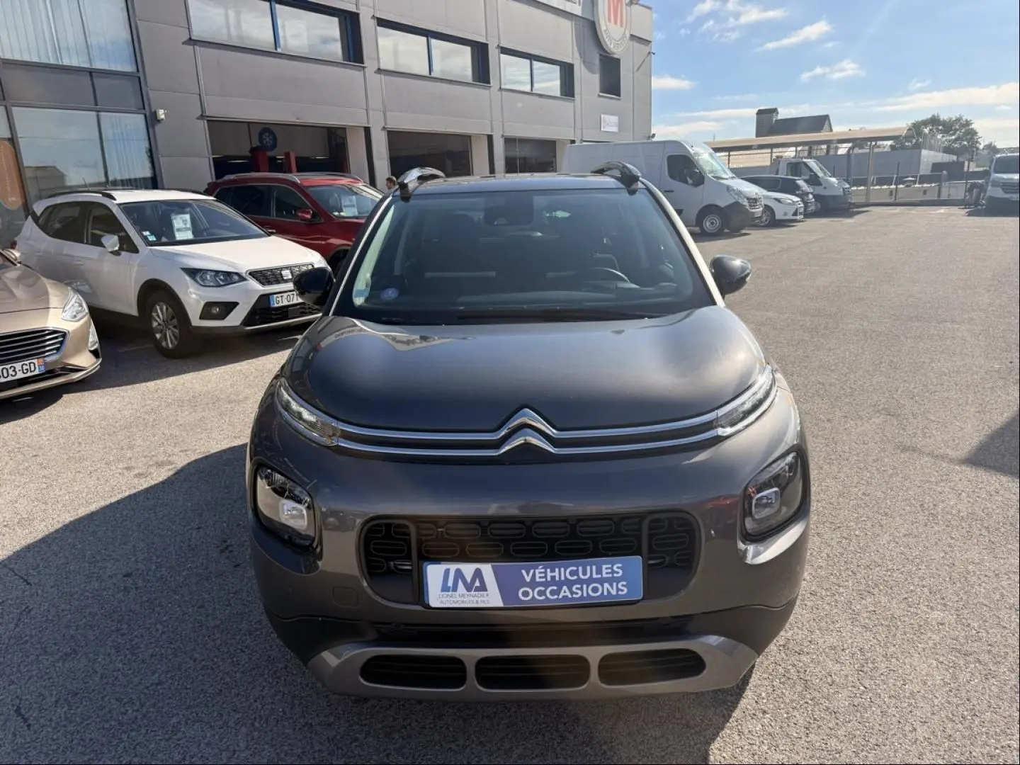 Citroën C3 Aircross gris métal vue de face, avec calandre distinctive et plaque "Véhicules Occasions" visible.