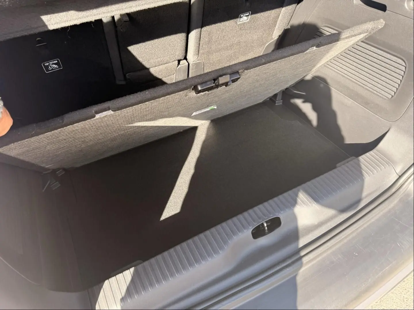 Vue rapprochée du coffre ouvert du Citroën C3 Aircross gris métal 2021, montrant le compartiment de rangement sous plancher.