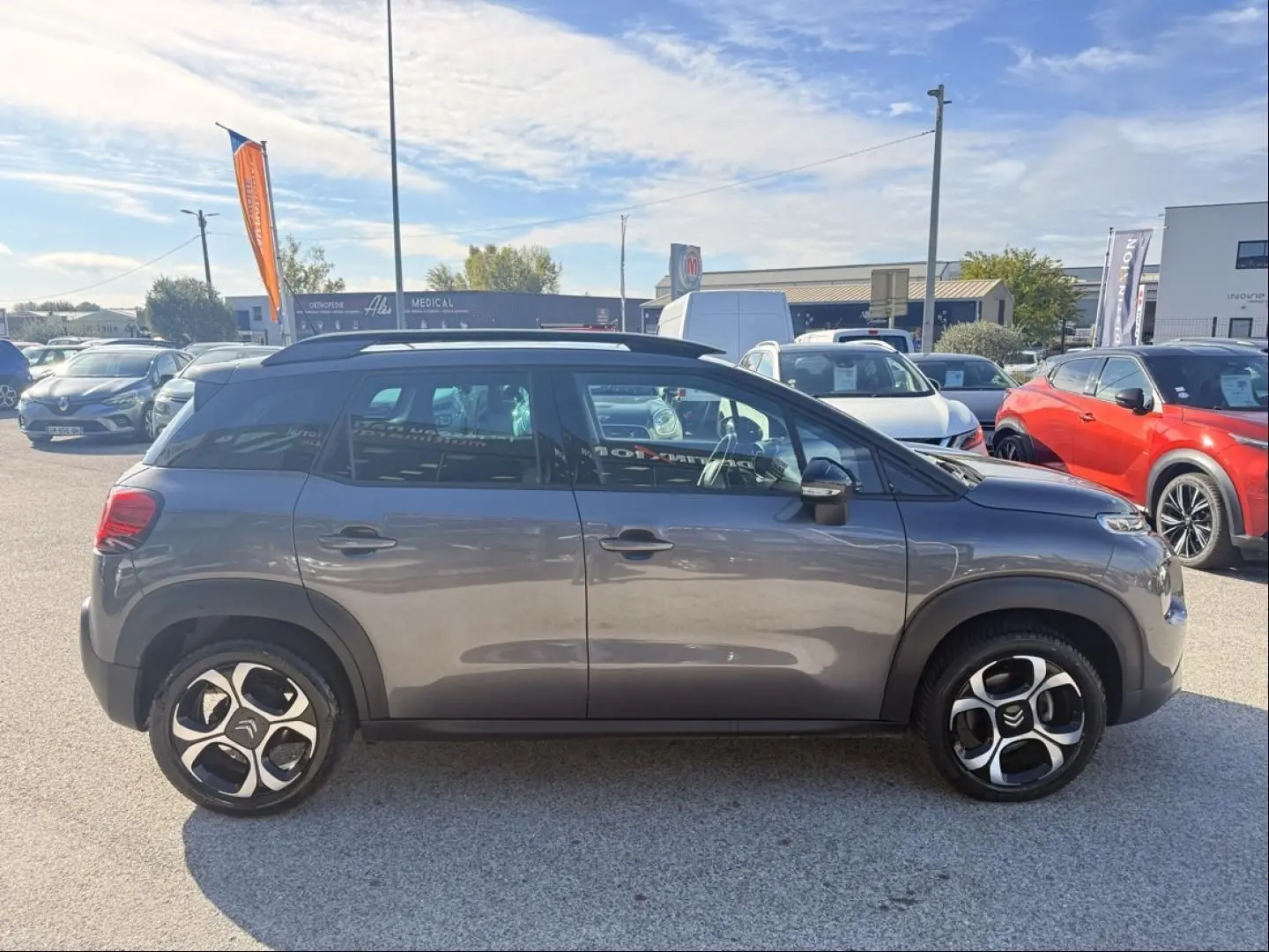 Vue de profil côté gauche d’un Citroën C3 Aircross gris métal 2021 avec jantes distinctives et toit noir.