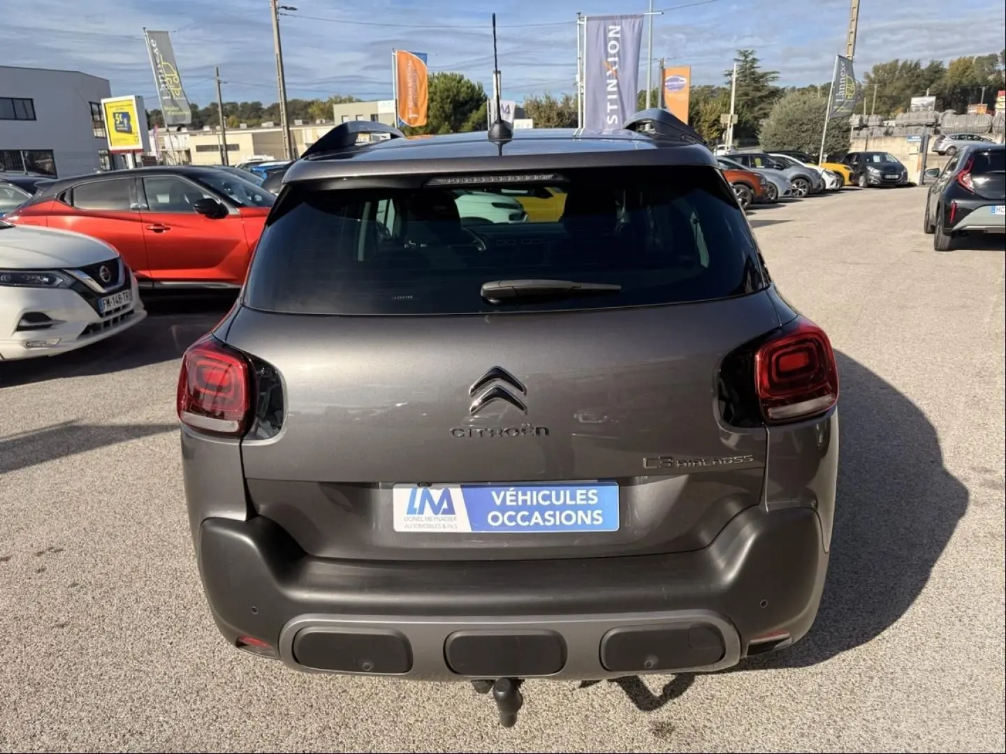 Vue arrière d’un Citroën C3 Aircross gris métal 2021 avec feux arrière carrés et attelage visible sur parking.