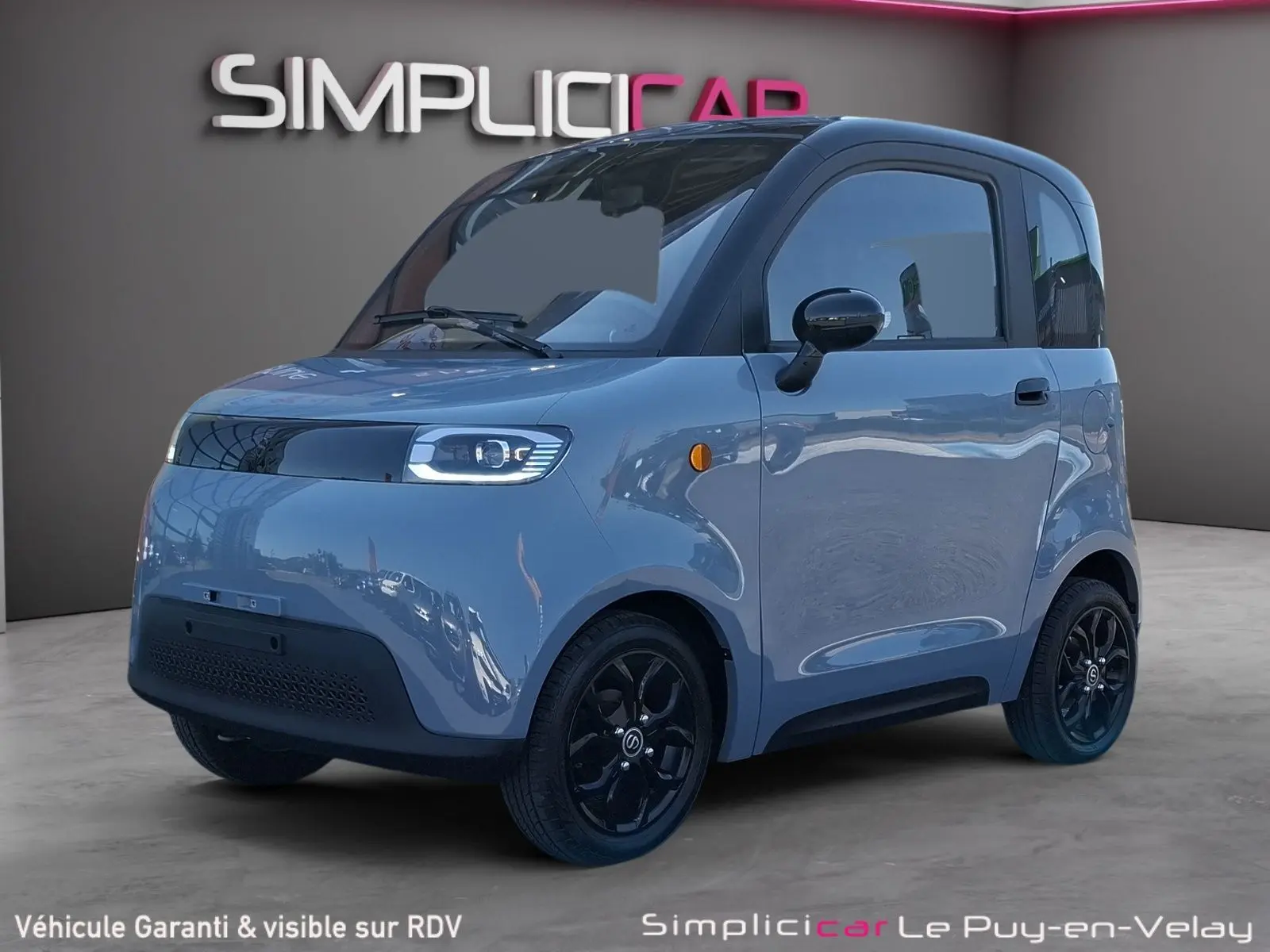 Vue 3/4 avant droite de la SIMPLICI S1 électrique 2025 gris perle avec toit noir et jantes noires brillantes.