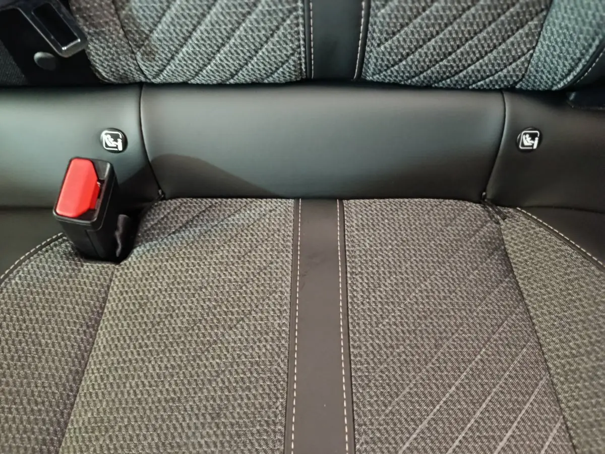 Détail de la banquette arrière grise de la Peugeot 208 PureTech 100 S&S Allure avec ceinture de sécurité rouge.