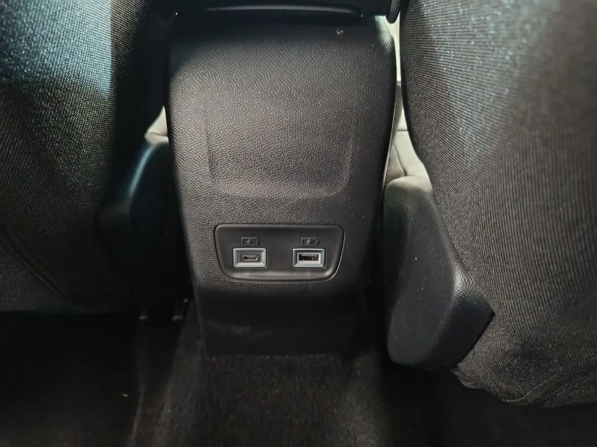 Prise USB avant et arrière visibles entre les sièges avant d'une Peugeot 208 gris foncé, version 2025.