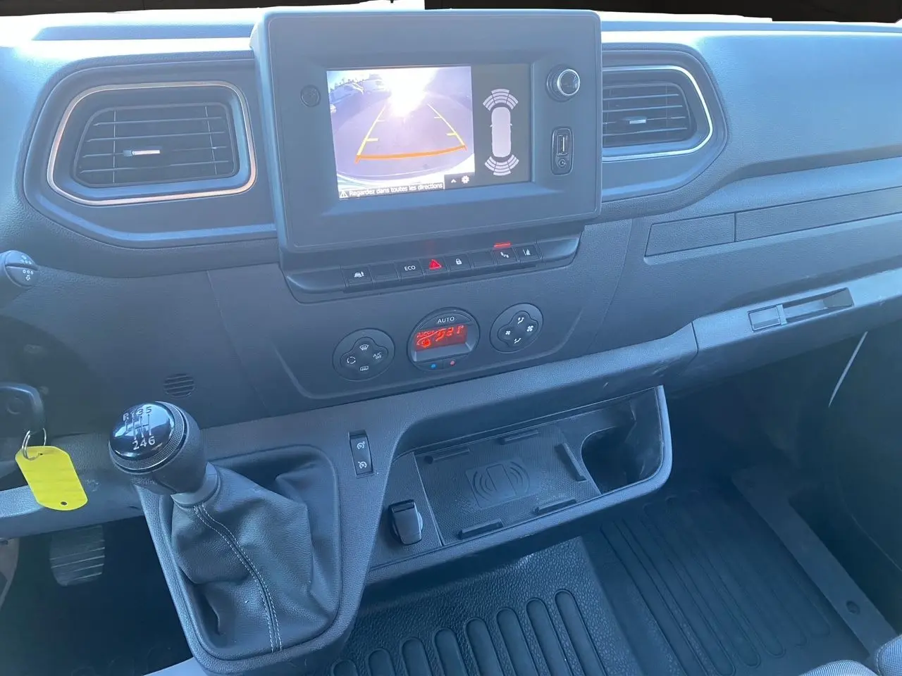 Vue rapprochée de l’intérieur du Nissan Interstar 2022 montrant la console centrale avec écran caméra de recul et levier de vitesses manuel.