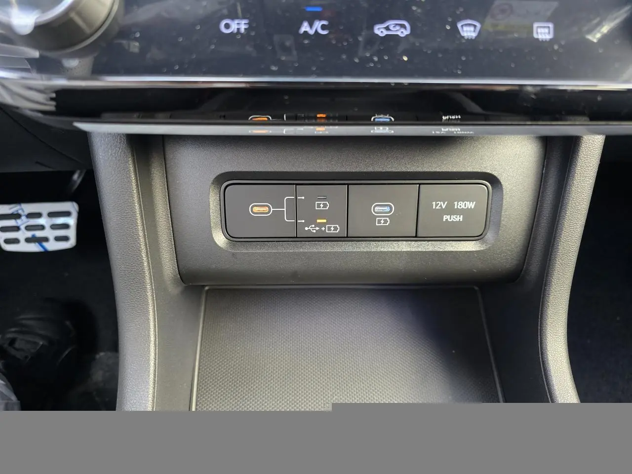 Gros plan sur la console centrale du Hyundai Tucson 2025, montrant prises USB-C et prise 12V, finition noire.