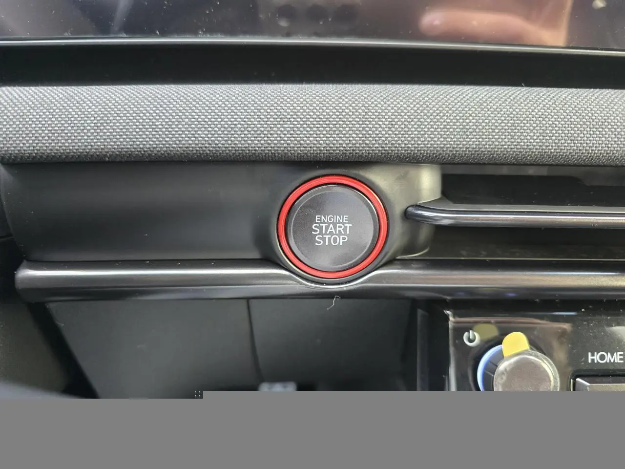 Gros plan sur le bouton start/stop entouré de rouge dans l’habitacle noir du Hyundai Tucson 2025.