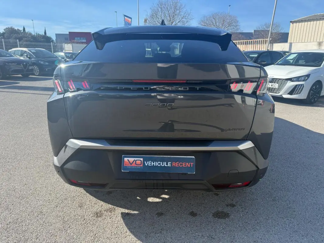 Vue arrière d’un Peugeot 3008 Hybrid gris 2025 avec feux arrière à griffes et plaque VÉHICULE RÉCENT.
