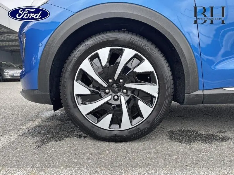 Gros plan sur la roue avant gauche d’un Ford Puma 2023 bleu Fashion Island avec jante alliage bicolore distincte.