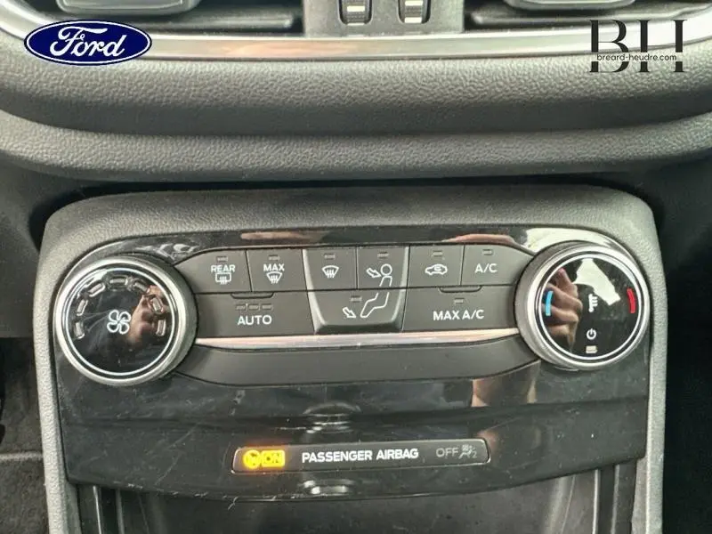 Vue rapprochée du panneau de climatisation du Ford Puma 2023 en bleu Fashion Island, avec commandes tactiles et voyants lumineux.